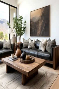 a living room with black leather couches and wooden coffee table in front of large windows