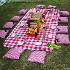 a picnic table set up with red and white checkered cloths