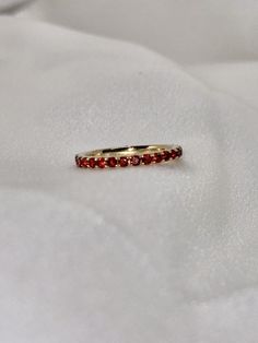 "A timeless and classic design, symbolizing commitment and love. Perfect for everyday wear or dressed up for special occasions. Make a bold statement in our Genuine Garnet Eternity Ring, handcrafted in 14k yellow gold. This ring is not adjustable and is available in US size 7 1/4.  Item Specifications: Materials: 14k Solid Yellow Gold Gemstone: Natural Garnet Total Gold Weight: 2.06 ct. Total Garnet Carat Weight: 1.22 ct.  ★  Each order will be beautifully packaged in a jewelry box and comes with a drawstring pouch that's perfect for travel. LiebeJewelry's products are handcrafted and all materials are genuine and ethically sourced. Our products are made with genuine materials and will not tarnish in the shower or irritate the skin. If you have any additional questions about this ring, jus Elegant Ruby Gemstone Eternity Band, Elegant Ruby Eternity Band, Elegant Ruby Stackable Rings With Round Band, Elegant Red Ruby Eternity Band, Elegant Red Round Eternity Band, Elegant Red Round Cut Eternity Band, Stackable Ruby Eternity Band In Yellow Gold, Luxury 14k Gold Stackable Ruby Ring, Yellow Gold Gemstone Eternity Band For Anniversary