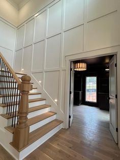 a staircase leading up to the second floor in a house with white walls and wood floors