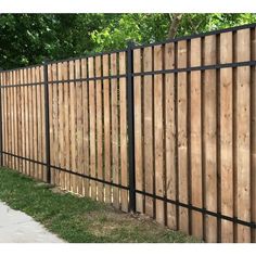 a wooden fence with black metal posts