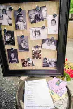 a bunch of pictures and papers are on a table next to a potted plant