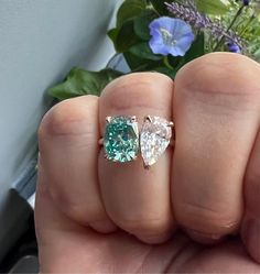 someone is holding two different colored diamonds in their hand, one has a blue and white diamond on it