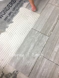 a man laying tile on top of a floor