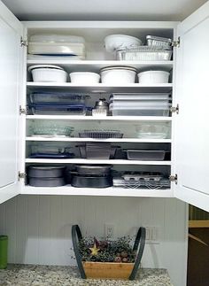 an open cabinet filled with dishes and bowls