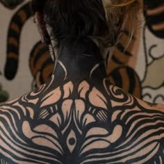 a woman with black and white tattoos on her back