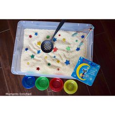 a plastic container filled with sand and spoons