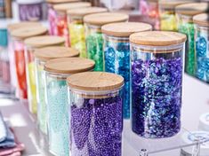 there are many jars with different colored beads in them