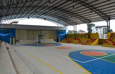 an indoor basketball court with blue and yellow painted walls