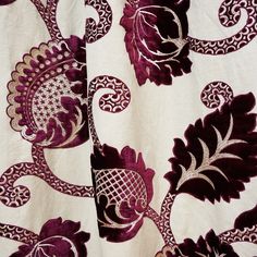 a close up of a purple and white fabric with floral designs on the bottom half