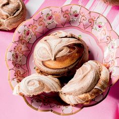 a pink plate topped with pastries on top of a table