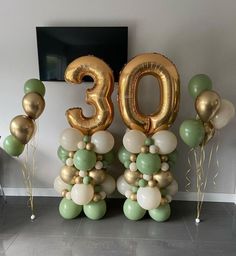 balloons and streamers are arranged in the shape of trees for an 30th birthday party