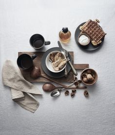 a table topped with plates and cups filled with food