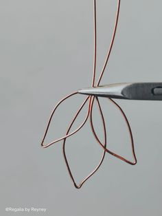 a pair of scissors that are on some kind of wire with leaves attached to it