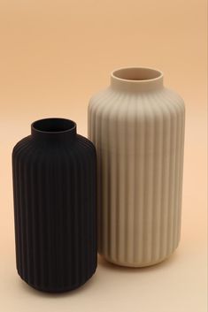 two black and white vases sitting next to each other