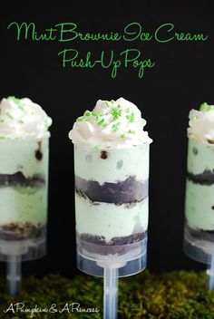 three desserts with green sprinkles in small cups on top of moss