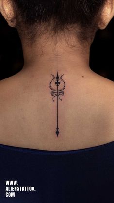 the back of a woman's neck with an arrow tattoo on her left side