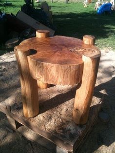 a wooden table sitting on top of a pile of wood