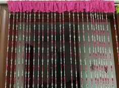 pink and silver beaded curtains hanging from a window