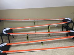 an orange and white track set sitting on top of a carpeted floor next to a black table