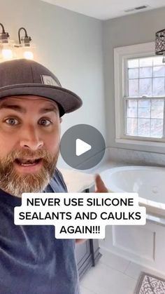 a man with a hat on in front of a bathtub and sink that says never use siloone sealants and caulks again again