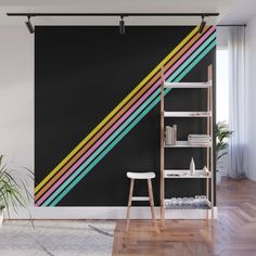 a room with a ladder and a blue wall that has a multicolored diagonal stripe on it