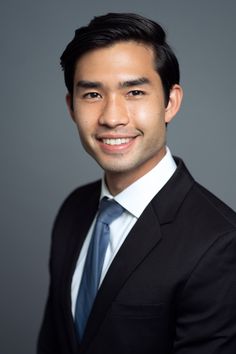 a man in a suit and tie smiling at the camera