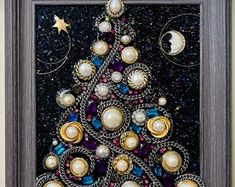 a christmas tree made out of beads and other items is displayed in a wooden frame