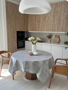 a kitchen with a table and two chairs in it, next to a stove top oven