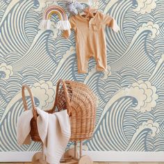 a baby's clothes hanging on the wall next to a wicker stroller