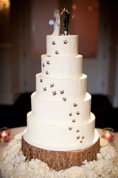 a wedding cake with white frosting and flowers on the bottom tier is topped with a bride and groom figurine