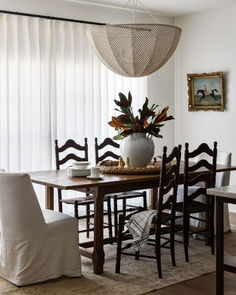 a dining room table with chairs and a potted plant on top of the table