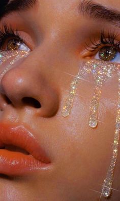 a close up of a woman's face with glitter on her eyes and eyelashes