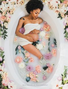 a woman in a bathtub surrounded by flowers