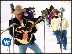 a man holding a guitar in front of microphones