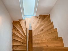 an overhead view of a wooden staircase with skylight