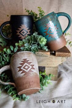 three coffee mugs sitting on top of wooden blocks