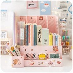 a pink desk organizer filled with books and stationery