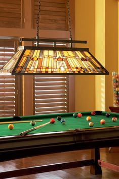 a pool table with a lamp hanging over it