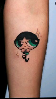 a woman's leg with a cartoon character tattoo on the side of her arm