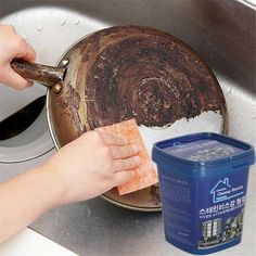 a person is cleaning the bottom of a sink