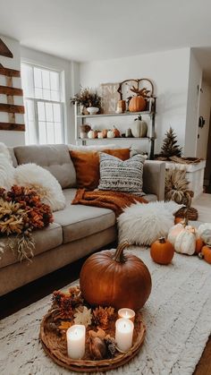 a living room filled with lots of pumpkins and other fall decorations on the floor