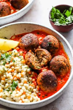 two bowls filled with meatballs, rice and garnished with cilantro