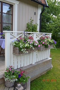 flowers are growing in baskets on the porch