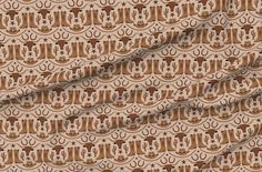 a brown and white fabric with an abstract design on the front, in different colors