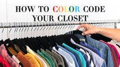 a person's hand is trying to find the right color for their clothes on a rack