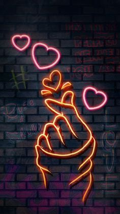 a brick wall with some neon lights on it and the words love spelled in different languages