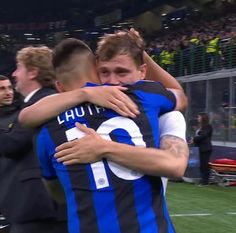 two soccer players hugging each other on the field