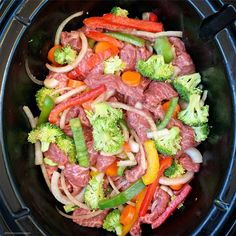 a close up of food in a crock pot with broccoli and peppers