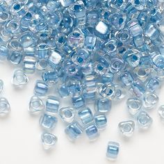 blue glass beads are scattered on a white surface